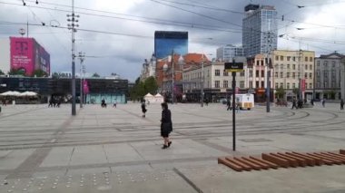 22-09-2022 Polonya, Katowice, Pazar Meydanı. Hiperlapse. Bulutlu bir günde eski bölgede şehir trafiği. Tramvay çalışıyor, insanlar yürüyor, kuşlar Avrupa şehrinin merkezinde hızlı çekim modunda uçuyor. Megalopolis 'te her gün.