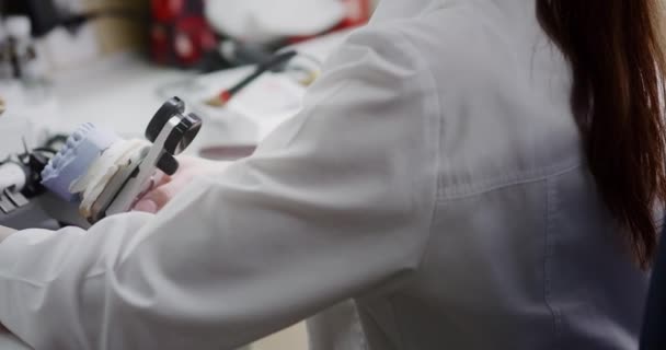 Seorang teknisi gigi memegang mock-up dari artikulator rahang di tangannya. — Stok Video
