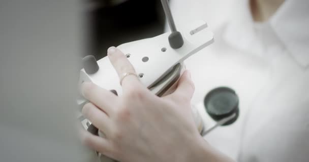 Egy fogtechnikus az állkapocs artikulátor mintáját tartja a kezében.. — Stock videók