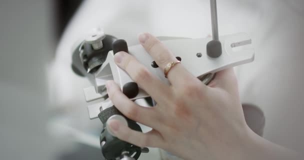 A dental technician holds a mock-up of the jaw articulator in his hands. — Stock Video