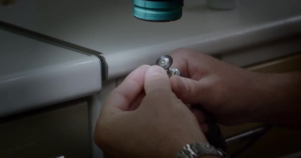 Mandlige hænder installere en tandkrone på kæben model. Hænderne på en protese. Nærbillede. Tandlæge-teknolog, tandtekniker-laboratorieassistent. Fremstilling af tandproteser og implantater – Stock-video