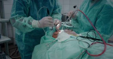 Doktor bademcikleri almak için pediatrik cerrahi bir operasyon yapıyor. Bademcik ameliyatı..