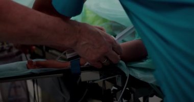 Hemşire damar içi infüzyon yapar ve ameliyata hazırlanır. Kateterli bir elin yakın çekimi..