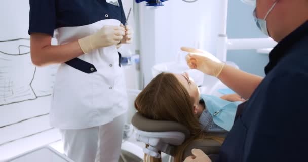 Stomatologul efectuează un examen folosind o oglindă dentară o femeie — Videoclip de stoc