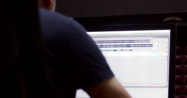 Bir müzik yapımcısı kayıt stüdyosundaki bilgisayarın başında oturuyor.. — Stok video