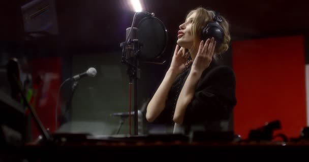 O femeie frumoasă cântă un cântec de dragoste în studioul de înregistrare — Videoclip de stoc