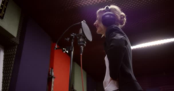 Mulher bonita canta uma canção de amor no estúdio de gravação — Vídeo de Stock