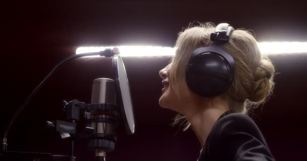 Beautiful woman sings a love song in recording studio — Stock Video