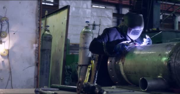 Профессиональный сварщик изготавливает металлоконструкции на заводе. — стоковое видео