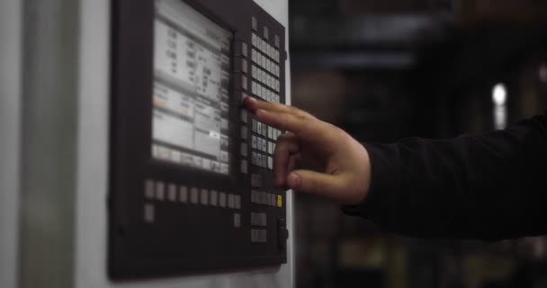 Profesjonalny pracownik w kasku stoi za maszyną CNC. — Wideo stockowe