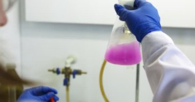 Makine yağı üretim tesisi. Gri plastik şişeler motor yağını doldurmak ve paketlemek için konveyör hattı boyunca hareket eder. Endüstriyel işletmeler için kayganlaştırıcı geliştirme, depolama ve tedarik. Kırmızı kamera..