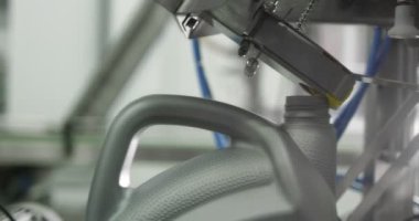 Makine yağı üretim tesisi. Gri plastik şişeler motor yağını doldurmak ve paketlemek için konveyör hattı boyunca hareket eder. Endüstriyel işletmeler için kayganlaştırıcı geliştirme, depolama ve tedarik. Kırmızı kamera..