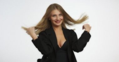 Uzun sarı saçlı güzel bir kadın gülümser ve hava öpücüğü gönderir..