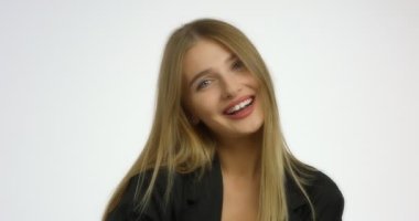 Uzun sarı saçlı güzel beyaz kadın gülümsüyor ve hava öpücüğü yolluyor..