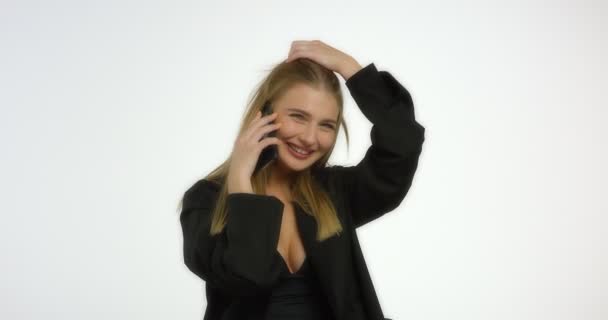 Mujer feliz con el pelo largo y rubio está hablando por teléfono y riendo. — Vídeos de Stock