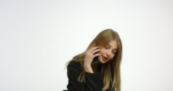 Schöne Frau im schwarzen Hemd telefoniert und glättet die Haare. — Stockvideo