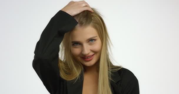 Schöne junge Frau posiert im Studio vor der Kamera auf weißem Hintergrund. — Stockvideo
