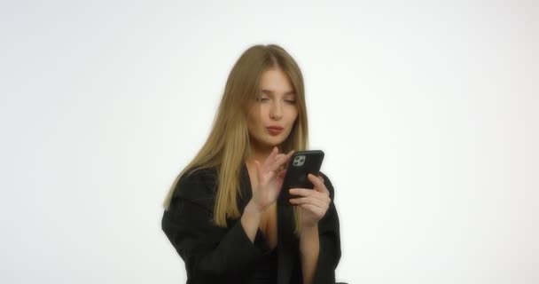 Schöne Frau tippt eine Nachricht am Telefon und chattet. — Stockvideo