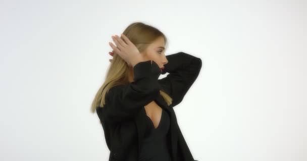 Smuk ung sexet kvinde i en sort skjorte tørrer hendes lange blonde hår. – Stock-video