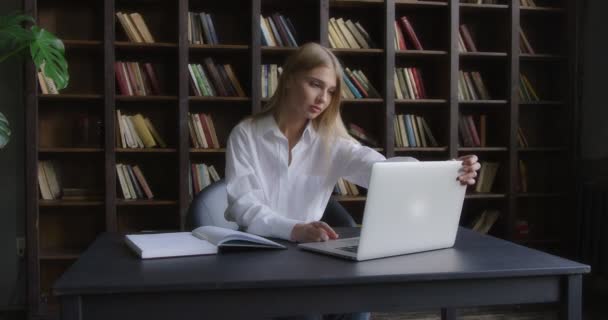 Zakelijke vrouw opent een laptop en neemt een notebook om notities te maken. — Stockvideo