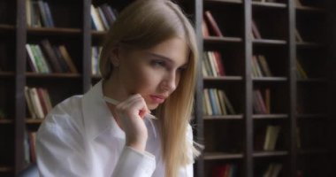 Beyaz gömlekli bir iş kadını dizüstü bilgisayarda çalışır ve notlar alır.. 