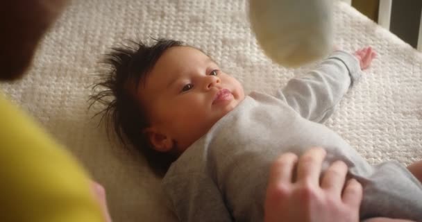 Happy young father playing with a newborn baby lying in a child crib. — Stockvideo