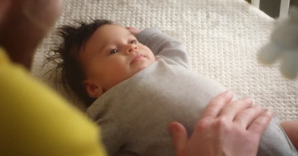 Joyeux jeune père jouant avec un nouveau-né couché dans un berceau d'enfant. — Video