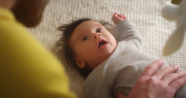 Glücklicher junger Vater streichelt Neugeborenes, das im Kinderbett liegt. — Stockvideo