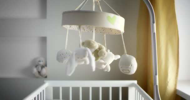 Baby mobile with different animals hanging over the child crib of a newborn — Stockvideo