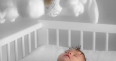 Newborn baby sleeping in a white child crib