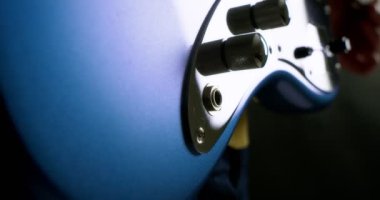 Erkek gitaristler mavi elektro gitarla parmak karıştırıyor.. 