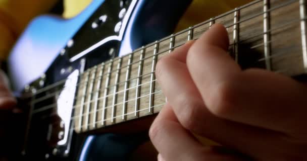 Erkek gitarist mavi bir elektro gitarda parmak karıştırma oyunu oynuyor.. — Stok video