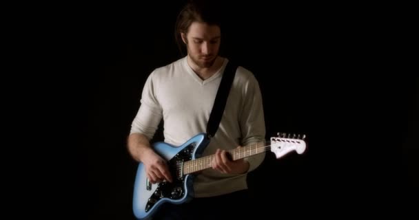 Siyah arka plandaki gri kazaklı yaratıcı müzisyen elektro gitar çalıyor.. — Stok video