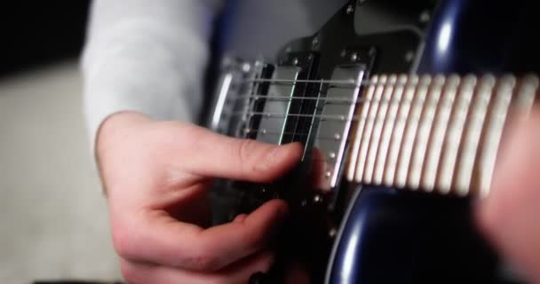 Närbild kreativ musiker som spelar fingerplocka med på en blå elgitarr. — Stockvideo