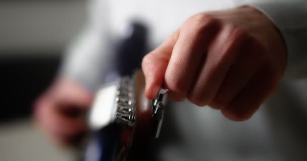 Detailní záběr kytaristy otočí knoflíky na krku kytary. — Stock video