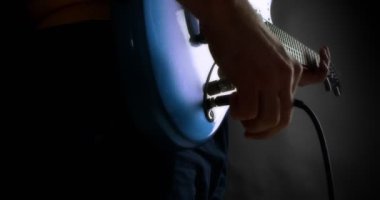 Erkek gitarist elektro gitarın fişini takıyor. Parmak karıştıran yaratıcı müzisyen