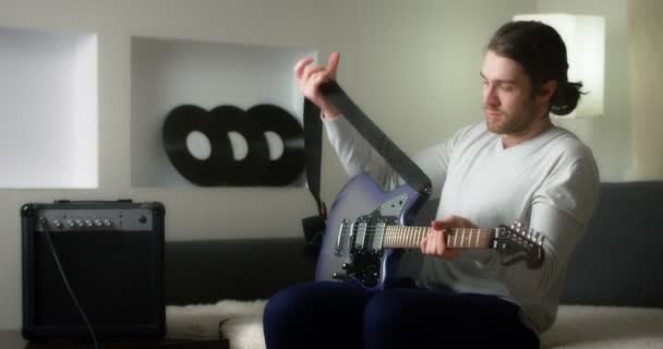 Гитарист играет свою музыку в домашней студии на фоне виниловых пластинок. — стоковое видео
