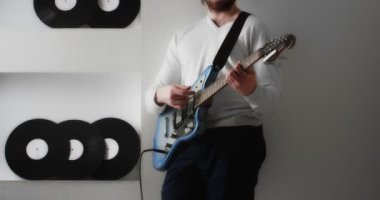 Genç adam evde elektro gitar çalıyor..