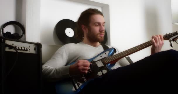 Joven toca la guitarra eléctrica en casa. — Vídeo de stock
