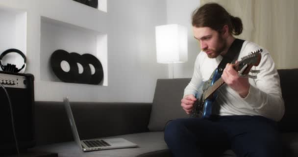 Genç adam öğretici bir video gitar dersi izler ve notları toplar. — Stok video