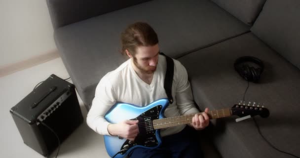 Joven toca la guitarra eléctrica en casa. — Vídeos de Stock