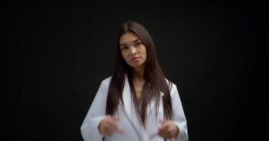 Beautiful brunette in a white jacket shows fuck you, two middle finger.