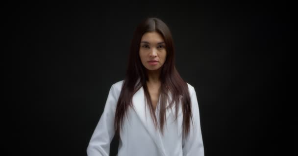 Beautiful brunette in a white jacket shows fuck you, the middle finger. — Stockvideo