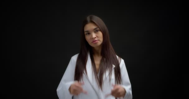 Beautiful brunette in a white jacket shows fuck you, two middle finger. — Vídeo de Stock