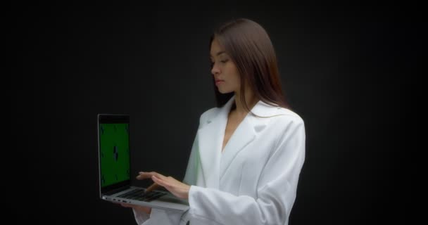 アジアの女性は、クロマキーでラップトップに入力し、 okのサインを示す. — ストック動画
