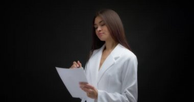 İş kadını, belgeyi okuyup onaylıyor ve imzasını atıyor..