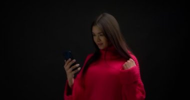 Pembe kazaklı kadın kopyalama için dikey yeşil telefon ekranı gösteriyor.