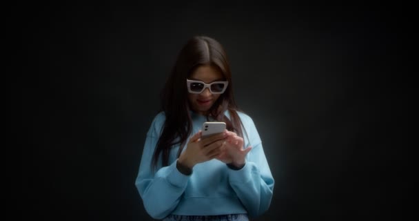 Junge positive asiatische Frau mit Sonnenbrille erhält eine lustige Chat-Nachricht. — Stockvideo