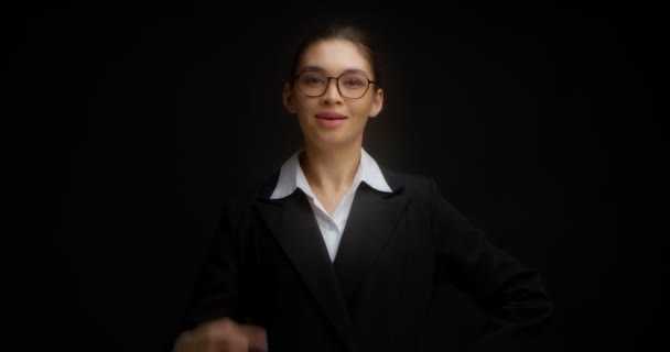 Mulher asiática de óculos sorrindo e mostra um dedo com a mão direita. — Vídeo de Stock