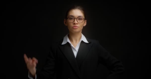 Mujer de negocios con gafas con una cara seria muestra dos dedos. — Vídeo de stock